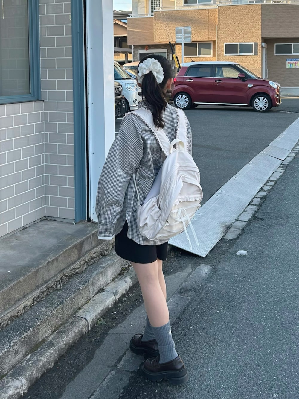 ホワイト系のシャツ/ブラウス、ブラック系のスラックス、ホワイト系のバックパック/リュックを着用したレディースの冬コーディネートの3枚目の写真