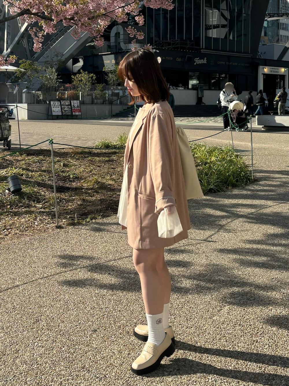 ピンク系のテーラードジャケット、ホワイト系のTシャツ/カットソー、ブラウン系のその他パンツを着用したレディースの春コーディネートの2枚目の写真