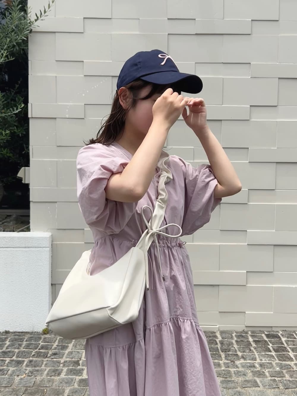 ピンク系のワンピース、ベージュ系のサンダル、ホワイト系のショルダーバッグを着用したレディースの夏コーディネートの2枚目の写真
