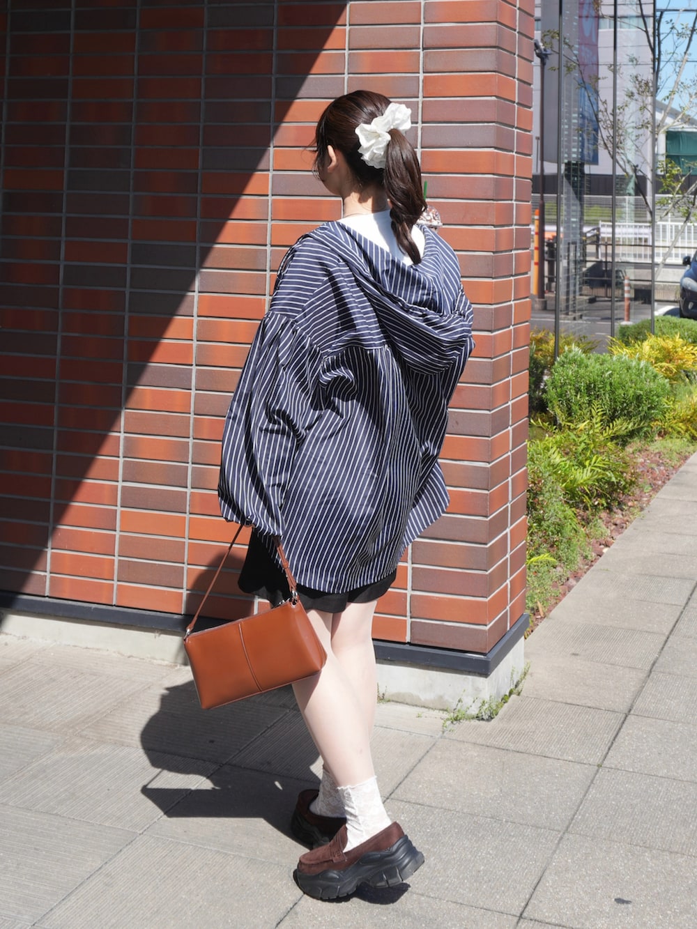 ブルー系のシャツ/ブラウス、ホワイト系のTシャツ/カットソー、ブラック系のスラックスを着用したレディースの春コーディネートの2枚目の写真