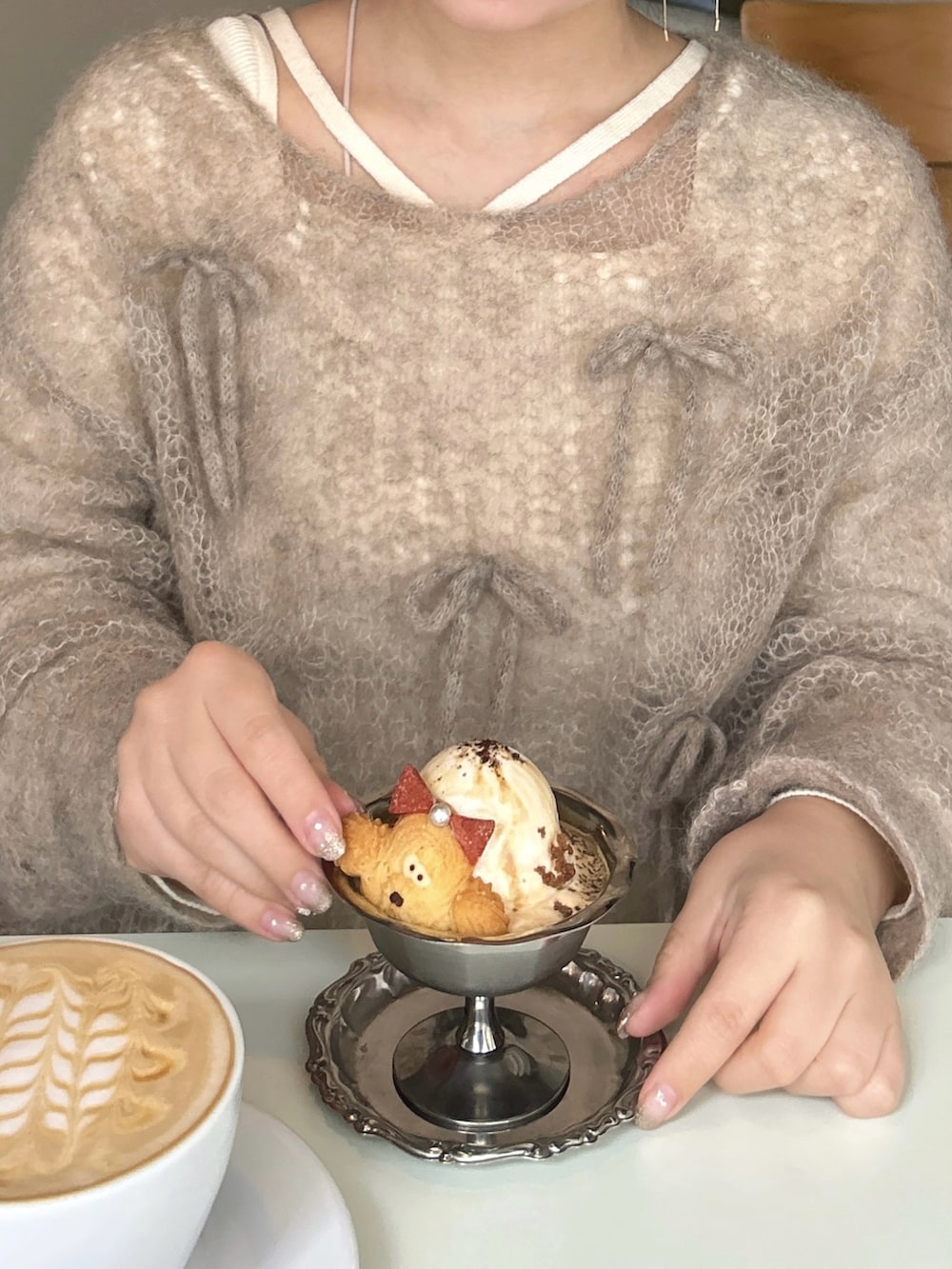 ブラウン系のニット/セーター、ホワイト系のニット/セーター、ホワイト系のスカートを着用したレディースの冬コーディネートの2枚目の写真