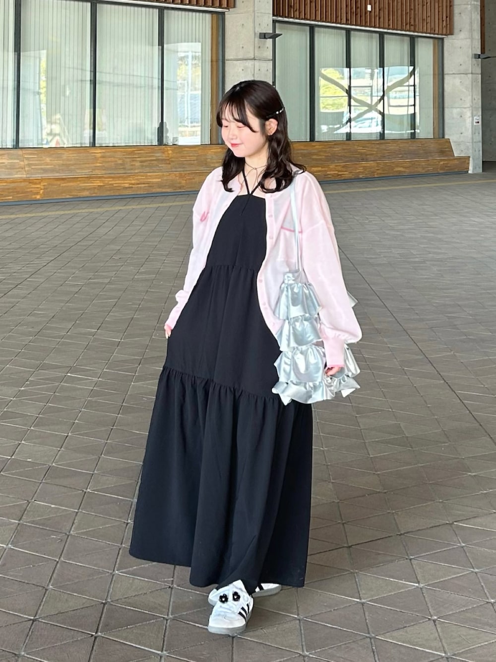 ホワイト系のワンピース、ピンク系のカーディガン/ボレロ、ホワイト系のスニーカーを着用したレディースの春コーディネートの2枚目の写真