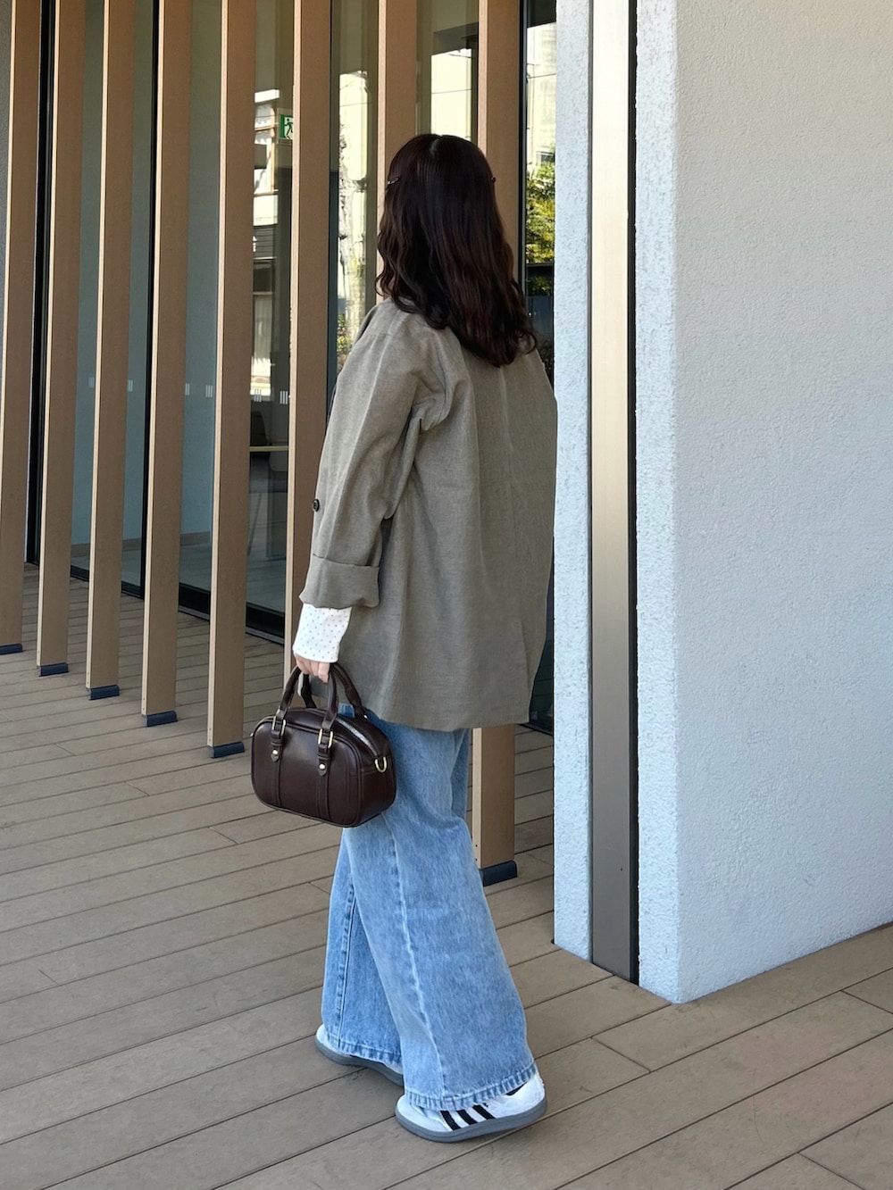 ホワイト系のTシャツ/カットソー、ベージュ系のテーラードジャケット、ブルー系のデニムパンツを着用したレディースの春コーディネートの3枚目の写真