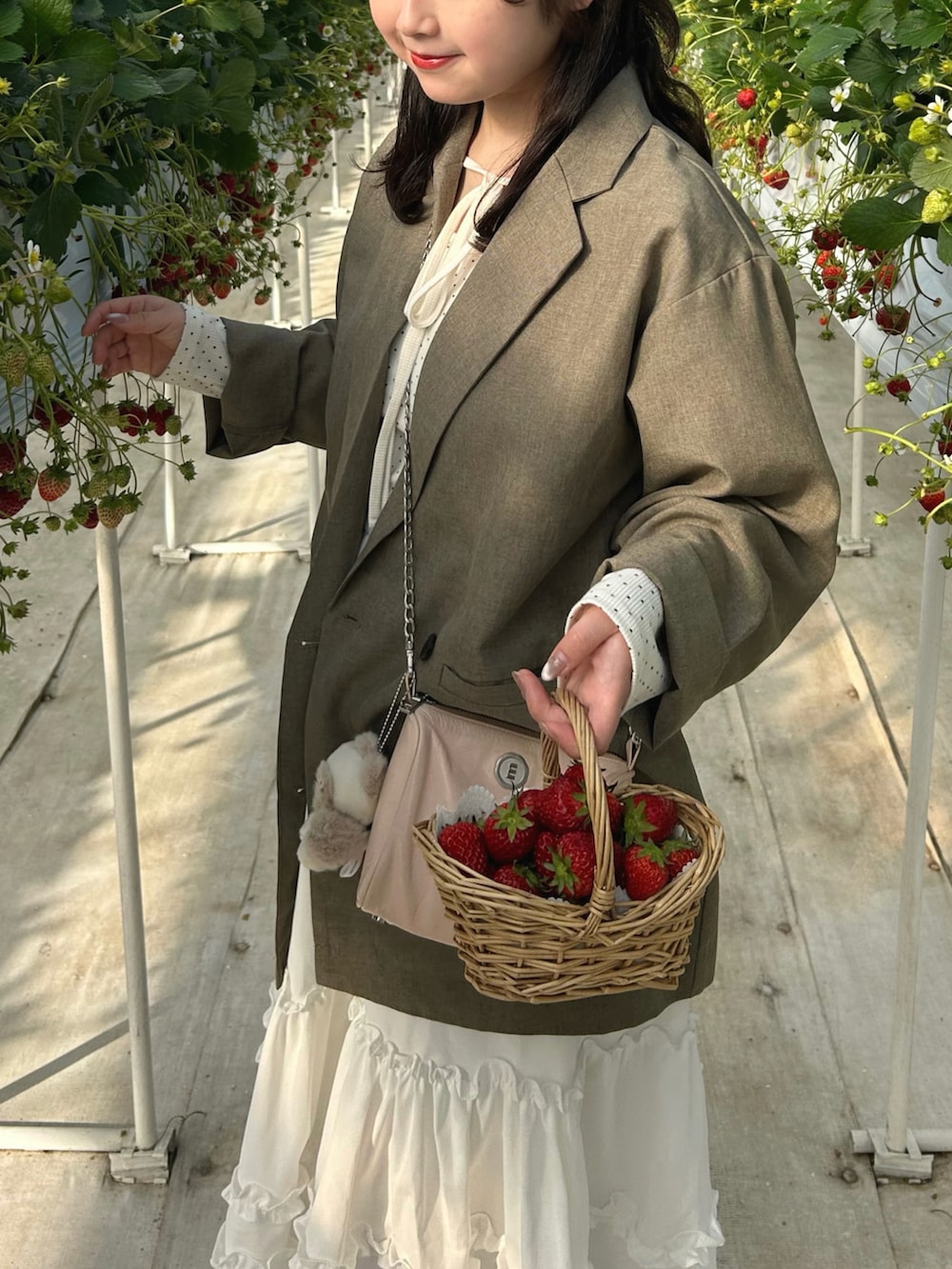 ホワイト系のTシャツ/カットソー、ベージュ系のテーラードジャケット、ホワイト系のスカートを着用したレディースの春コーディネートの4枚目の写真