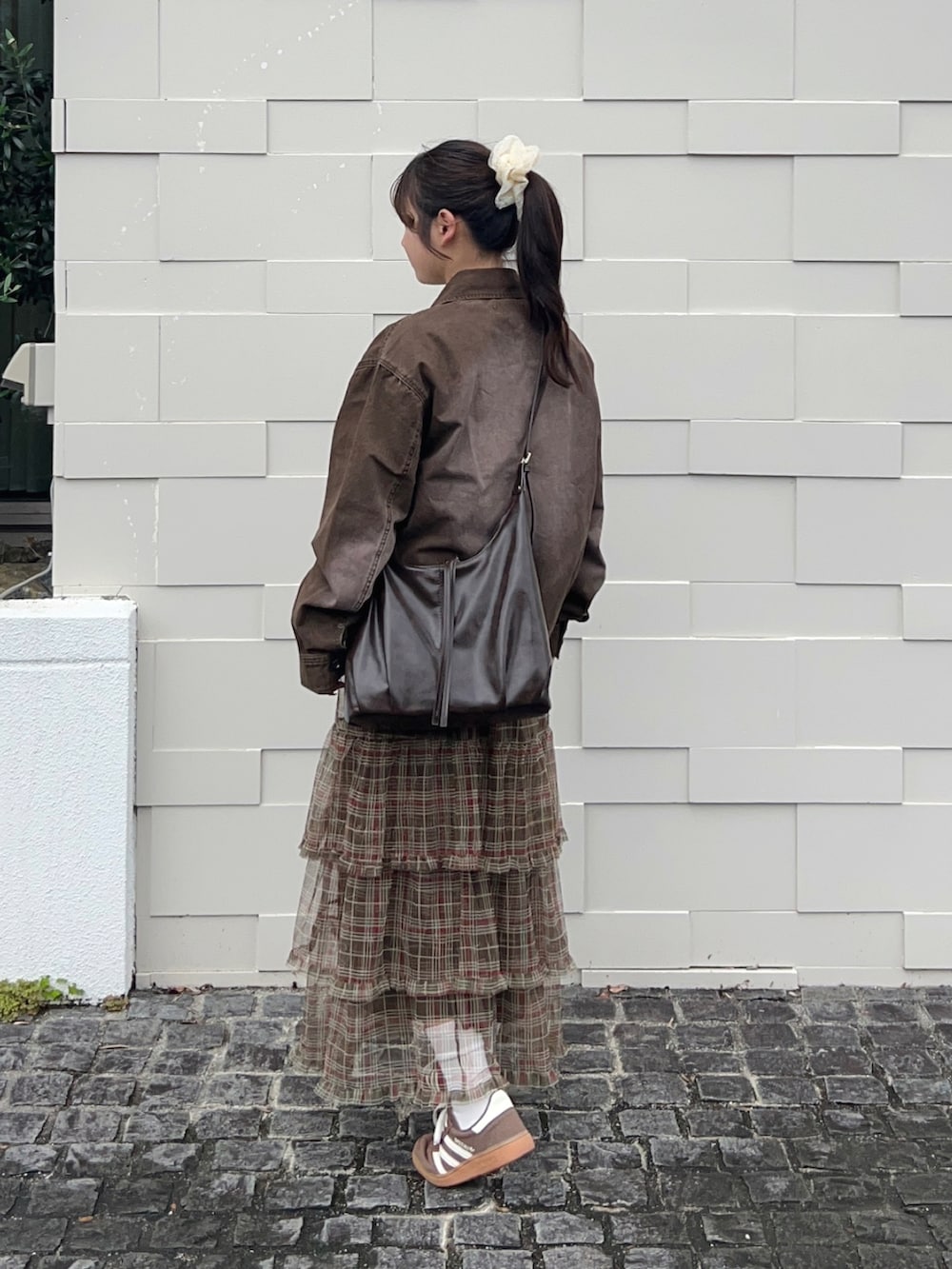 ブラウン系のスカート、ブラウン系のショルダーバッグ、ベージュ系のTシャツ/カットソーを着用したレディースの秋コーディネートの3枚目の写真