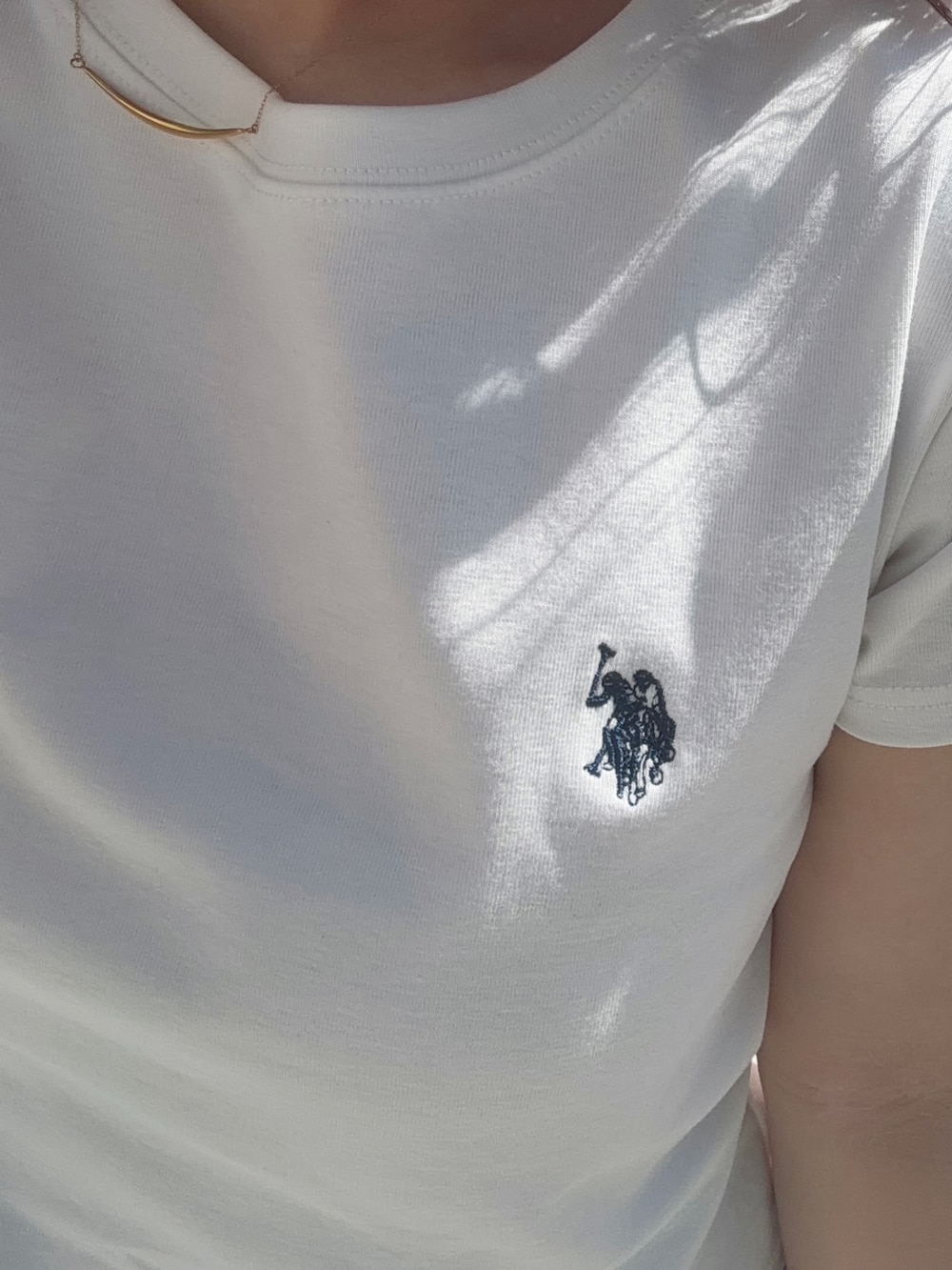 グレー系のスラックス、ホワイト系のTシャツ/カットソー、ホワイト系のスニーカーを着用したレディースの夏コーディネートの3枚目の写真