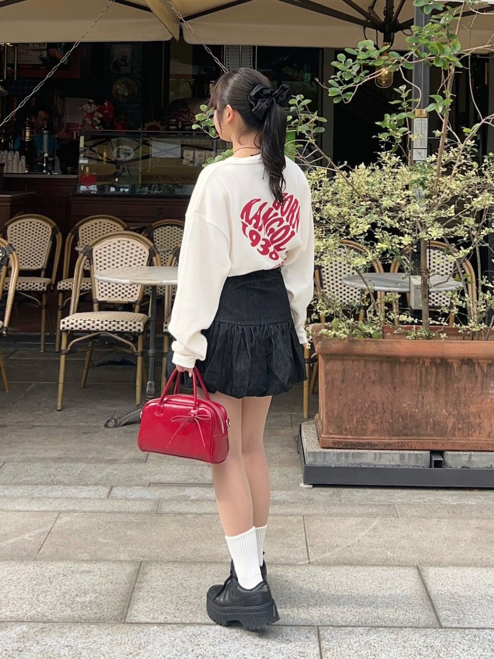 その他のTシャツ/カットソー、ブラック系のスカート、レッド系のボストンバッグを着用したレディースの秋コーディネートの5枚目の写真