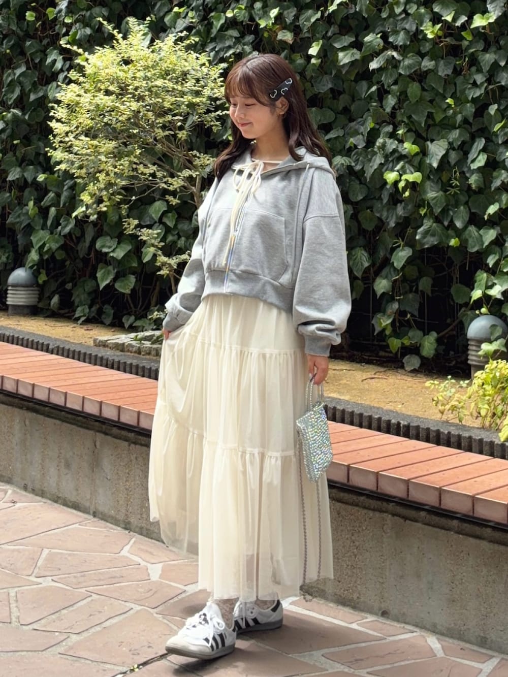 グレー系のパーカー、ホワイト系のスカート、ホワイト系のTシャツ/カットソーを着用したレディースの秋コーディネートの2枚目の写真