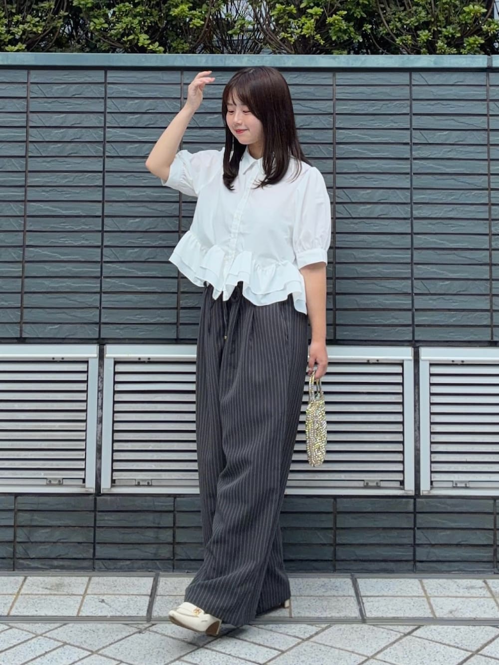 ホワイト系のシャツ/ブラウス、ホワイト系のパンプス、グレー系のスラックスを着用したレディースの夏コーディネートの2枚目の写真