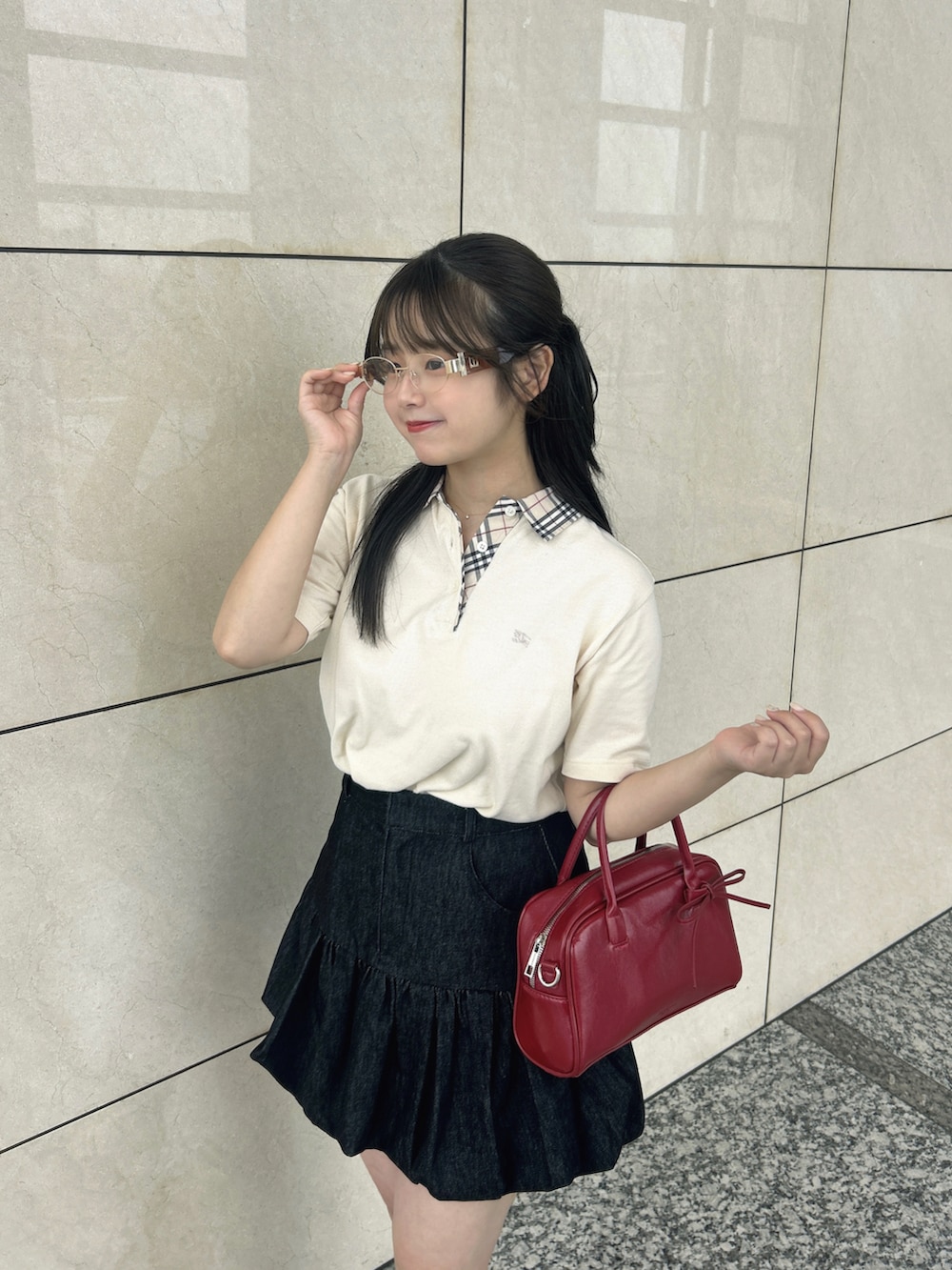 ブラック系のスカート、レッド系のボストンバッグ、ブラック系のパンプスを着用したレディースの夏コーディネートの2枚目の写真