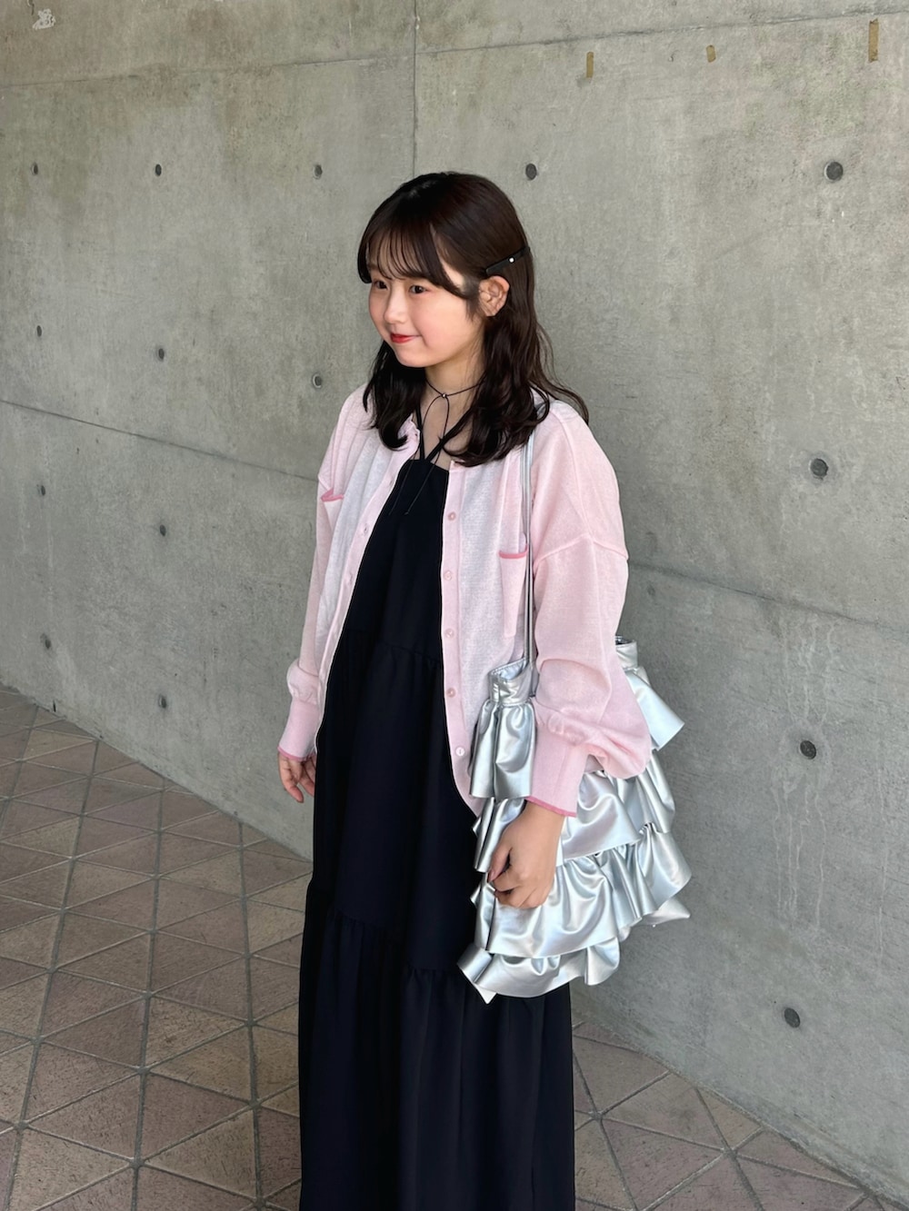 ホワイト系のワンピース、ピンク系のカーディガン/ボレロ、ホワイト系のスニーカーを着用したレディースの春コーディネートの3枚目の写真