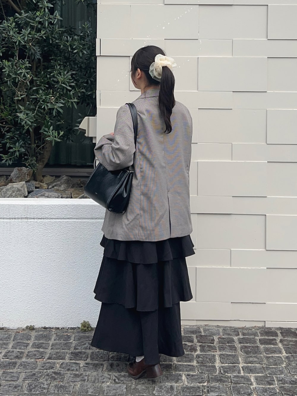 ブラウン系のテーラードジャケット、ブラウン系のパンプス、ホワイト系のニット/セーターを着用したレディースの秋コーディネートの4枚目の写真