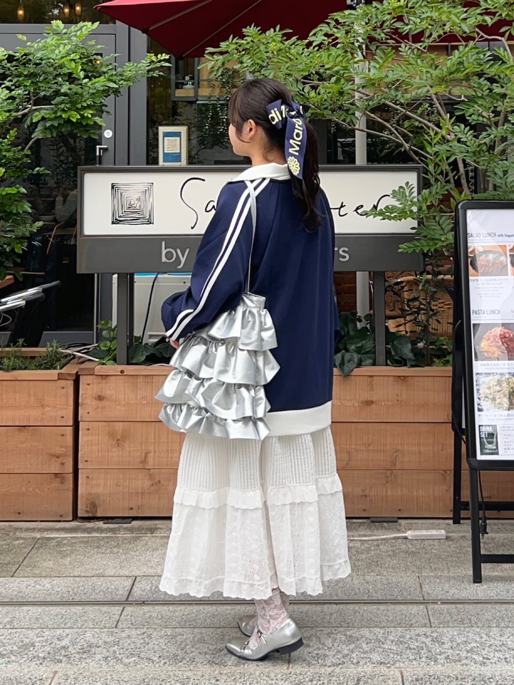 ブルー系のジャージ、ホワイト系のスカート、シルバー系のパンプスを着用したレディースの秋コーディネートの2枚目の写真