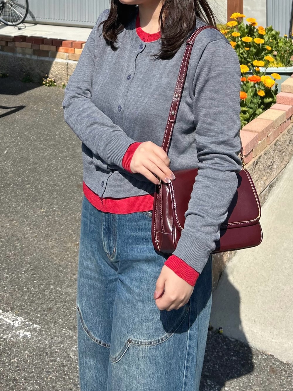 グレー系のカーディガン/ボレロ、ブラウン系のローファー、レッド系のショルダーバッグを着用したレディースの春コーディネートの4枚目の写真
