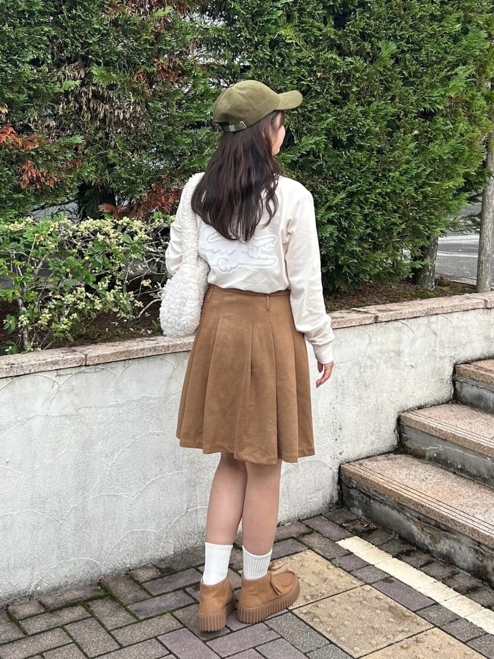 ベージュ系のモカシン/デッキシューズ、ベージュ系のTシャツ/カットソー、ベージュ系のスカートを着用したレディースの秋コーディネートの2枚目の写真