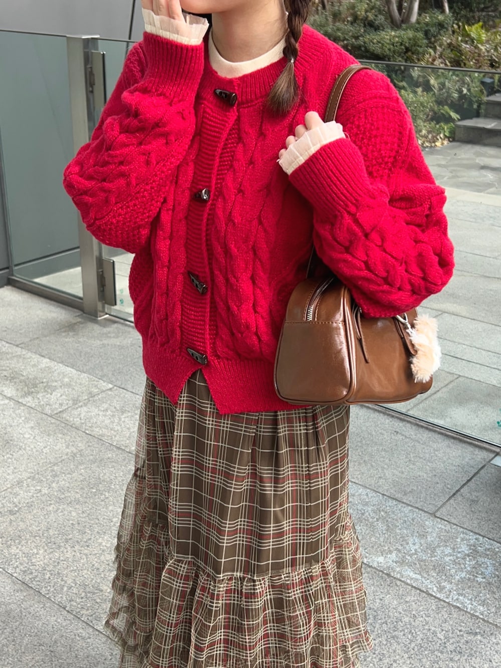 レッド系のニット/セーター、ホワイト系のニット/セーター、ブラウン系のスカートを着用したレディースの冬コーディネートの2枚目の写真