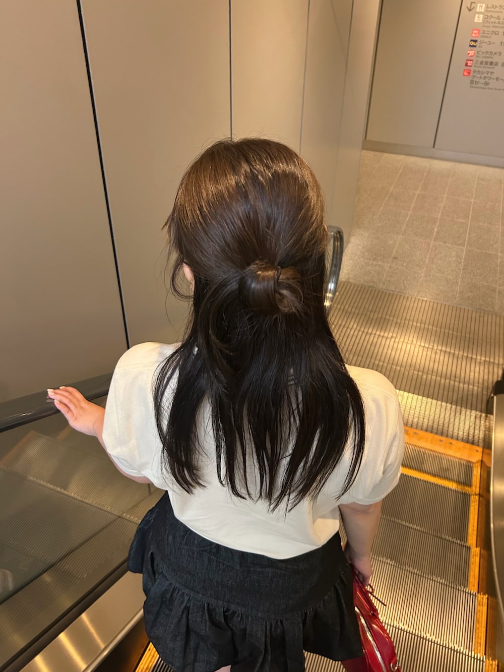 ブラック系のスカート、レッド系のボストンバッグ、ブラック系のパンプスを着用したレディースの夏コーディネートの5枚目の写真