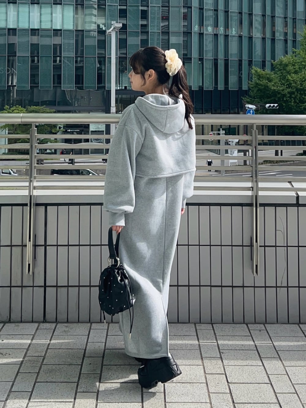 ブラック系のスニーカー、グレー系のワンピース、ブラック系のハンドバッグを着用したレディースの秋コーディネートの2枚目の写真