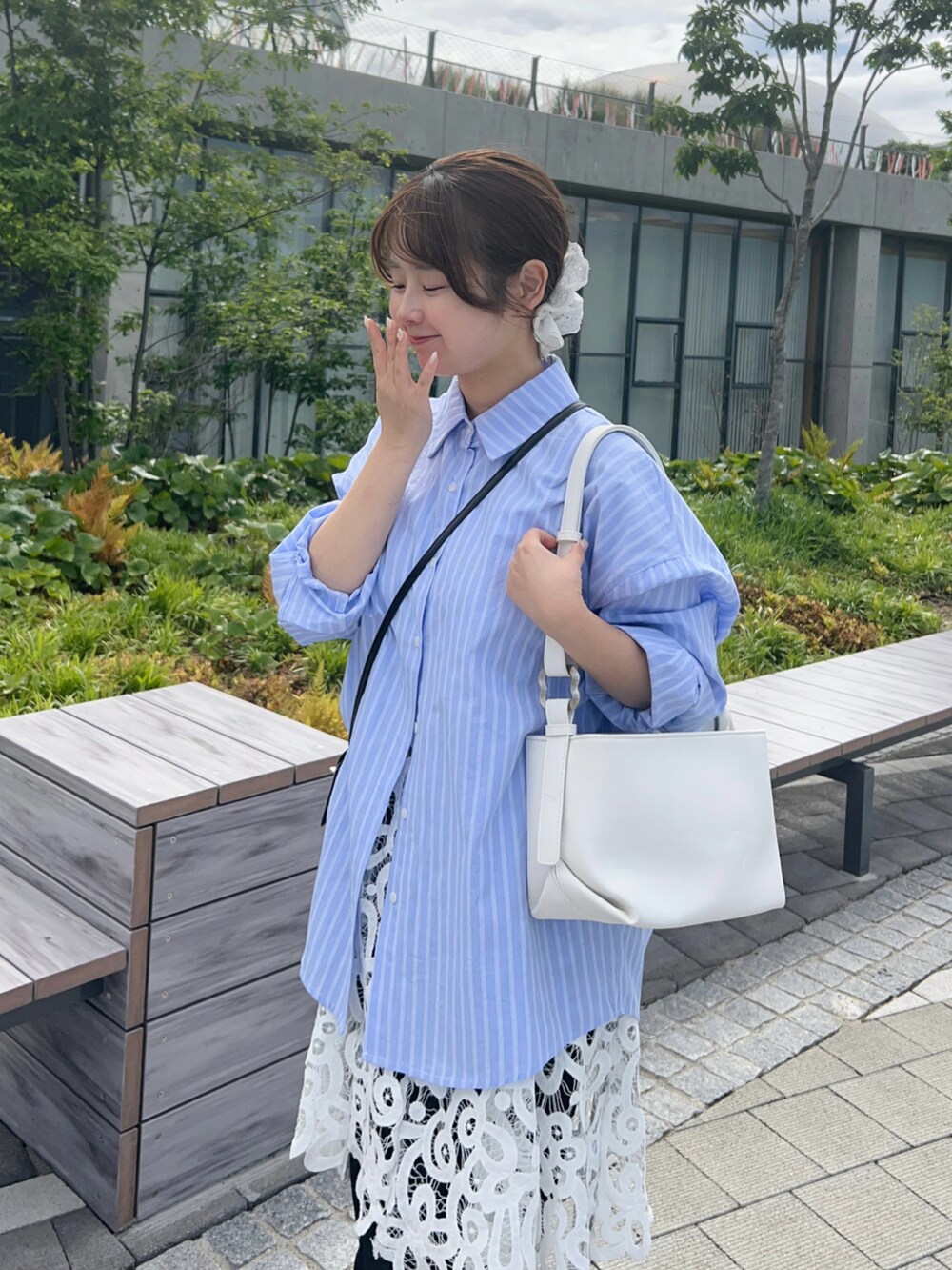 ブルー系のシャツ/ブラウス、ホワイト系のチュニック、ブルー系のデニムパンツを着用したレディースの春コーディネートの3枚目の写真