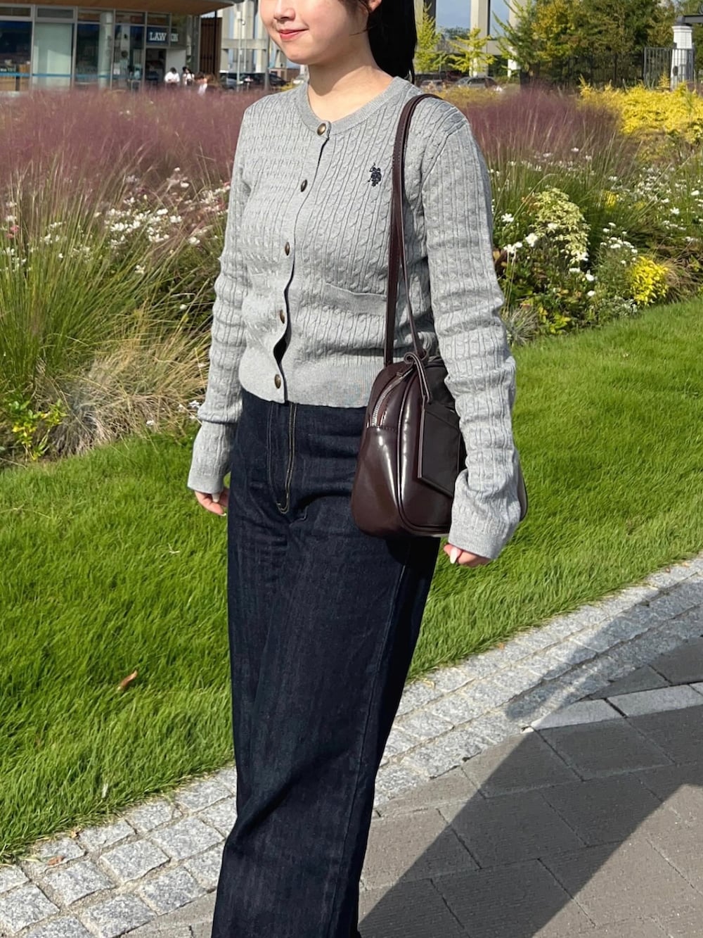 グレー系のカーディガン/ボレロ、ブラウン系のショルダーバッグ、シルバー系のパンプスを着用したレディースの秋コーディネートの3枚目の写真