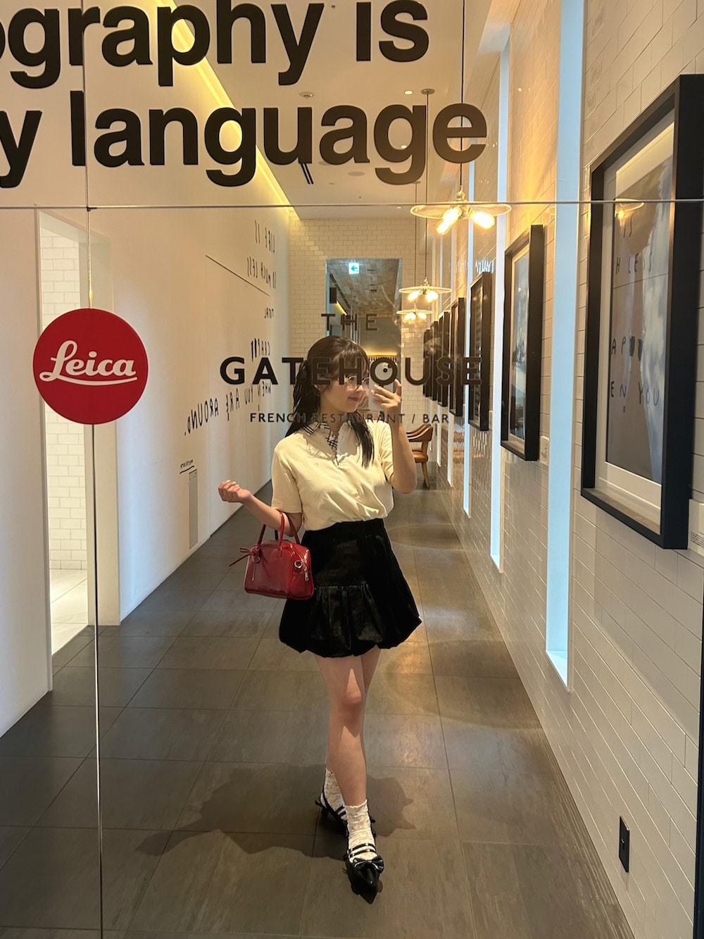 ブラック系のスカート、レッド系のボストンバッグ、ブラック系のパンプスを着用したレディースの夏コーディネートの4枚目の写真