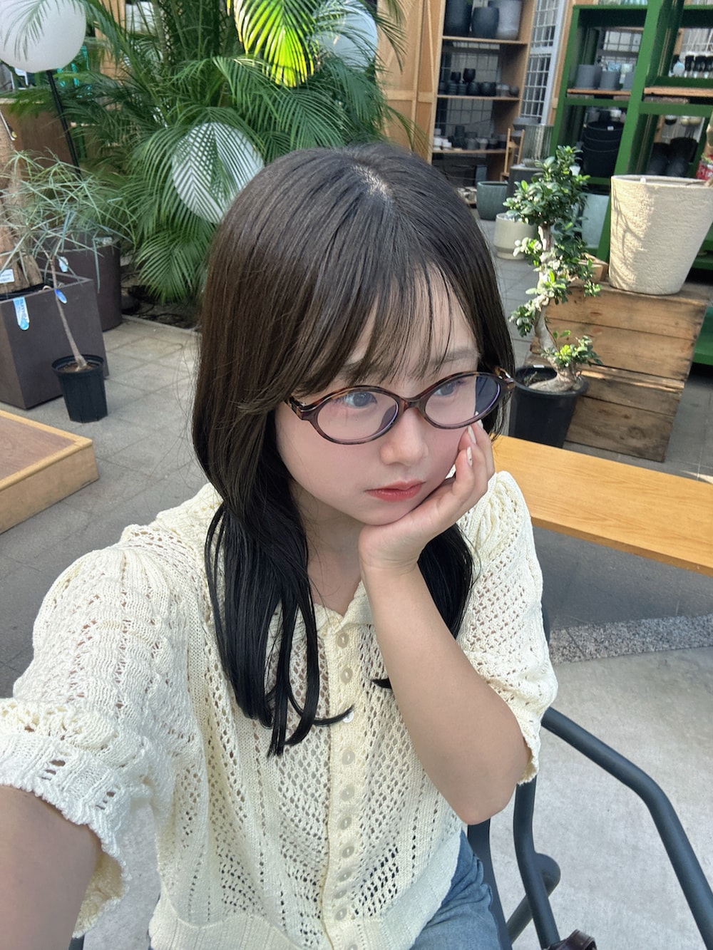 イエロー系のニット/セーター、ブルー系のデニムパンツ、ブラウン系のスニーカーを着用したレディースの夏コーディネートの2枚目の写真