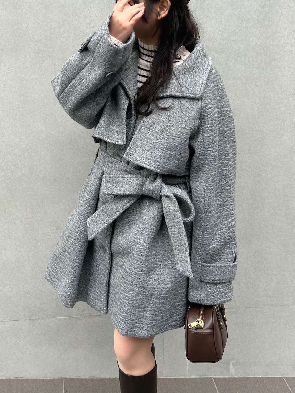 ホワイト系のニット/セーター、グレー系のステンカラーコート、ブラック系のスラックスを着用したレディースの冬コーディネートの3枚目の写真