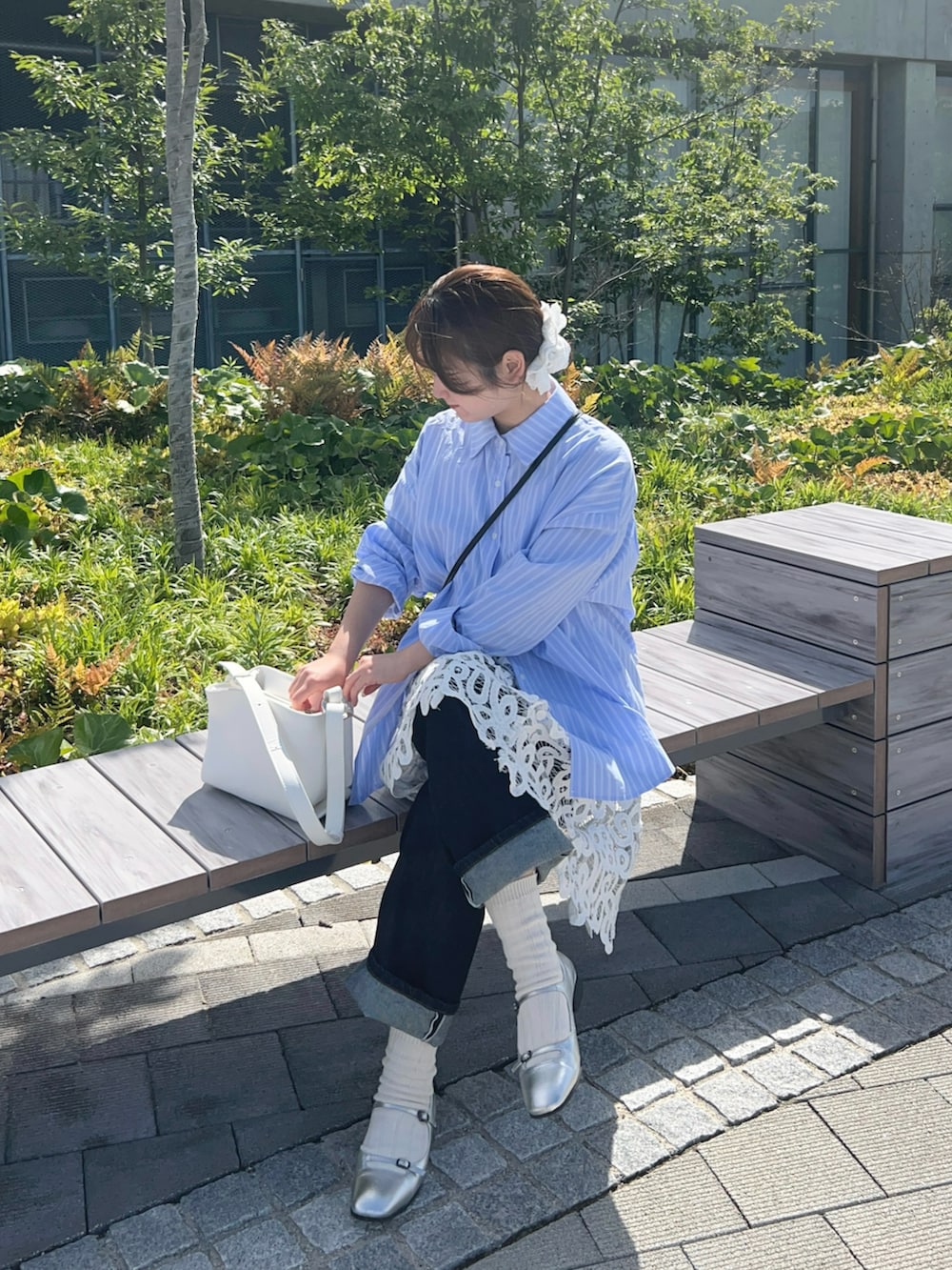 ブルー系のシャツ/ブラウス、ホワイト系のチュニック、ブルー系のデニムパンツを着用したレディースの春コーディネートの4枚目の写真