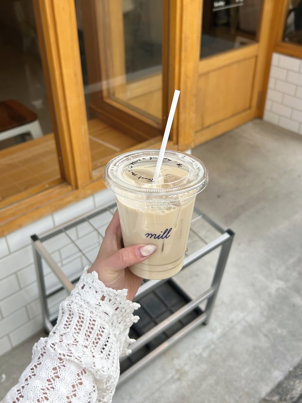 ベージュ系のかごバッグ、ホワイト系のカーディガン/ボレロ、ブルー系のシャツワンピースを着用したレディースの春コーディネートの4枚目の写真