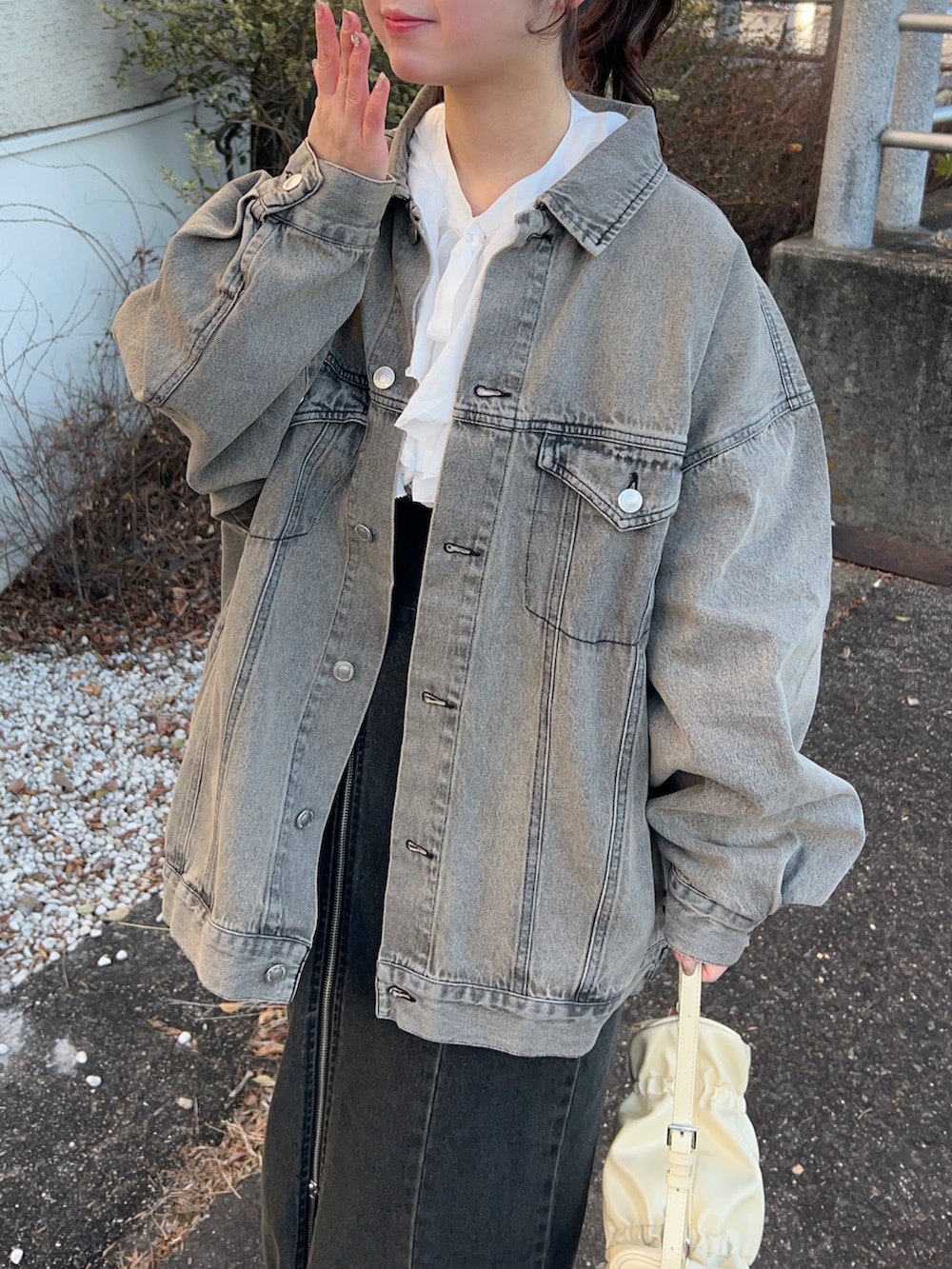 ブラック系のデニムジャケット、ホワイト系のシャツ/ブラウス、ブラック系のスカートを着用したレディースの冬コーディネートの2枚目の写真