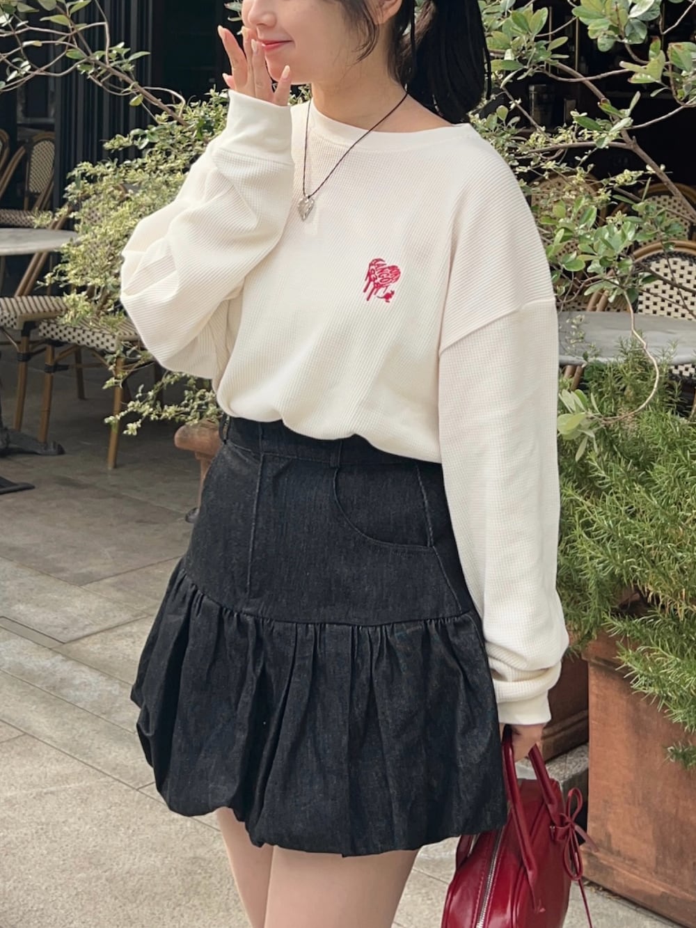 その他のTシャツ/カットソー、ブラック系のスカート、レッド系のボストンバッグを着用したレディースの秋コーディネートの4枚目の写真