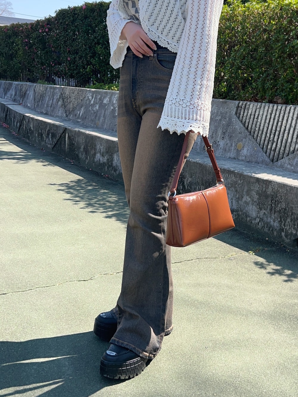 ブラック系のスニーカー、ブルー系のデニムパンツ、その他のショルダーバッグを着用したレディースの春コーディネートの5枚目の写真