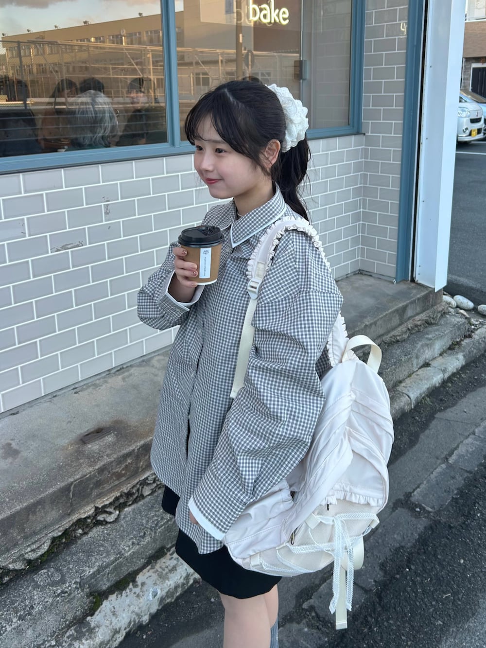 ホワイト系のシャツ/ブラウス、ブラック系のスラックス、ホワイト系のバックパック/リュックを着用したレディースの冬コーディネートの4枚目の写真