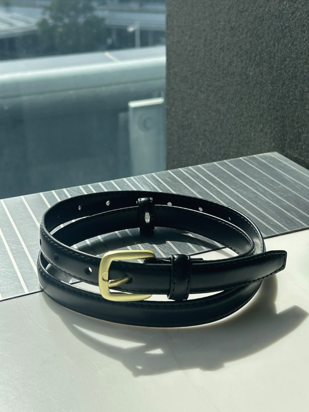 ブルー系のシャツ/ブラウス、ブラック系のその他パンツ、ブラウン系のボストンバッグを着用したレディースの春コーディネートの4枚目の写真