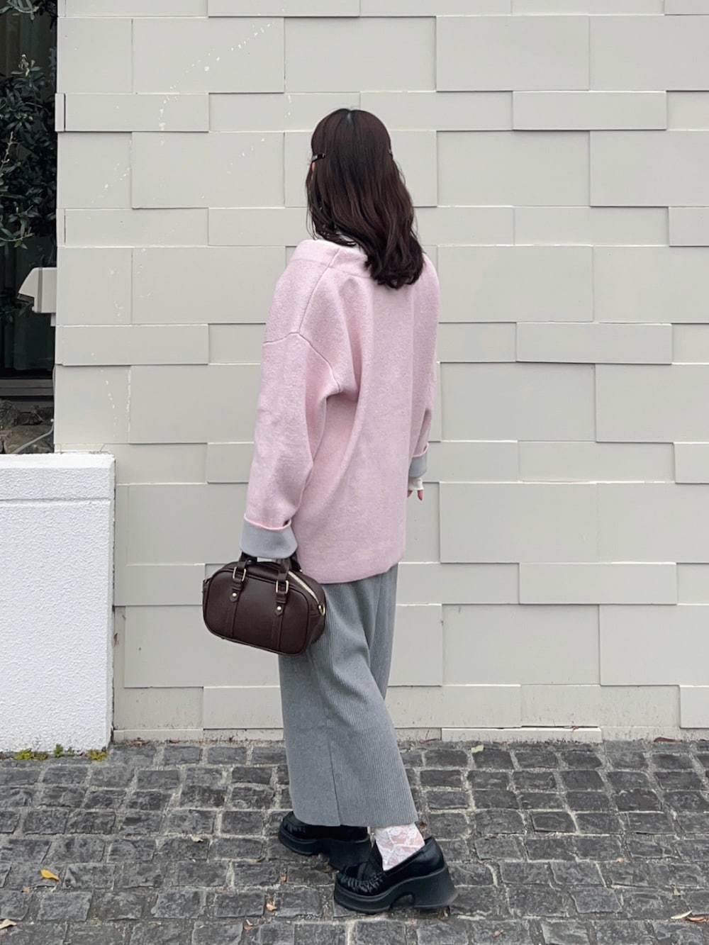 ピンク系のカーディガン/ボレロ、ホワイト系のTシャツ/カットソー、グレー系のスカートを着用したレディースの春コーディネートの2枚目の写真