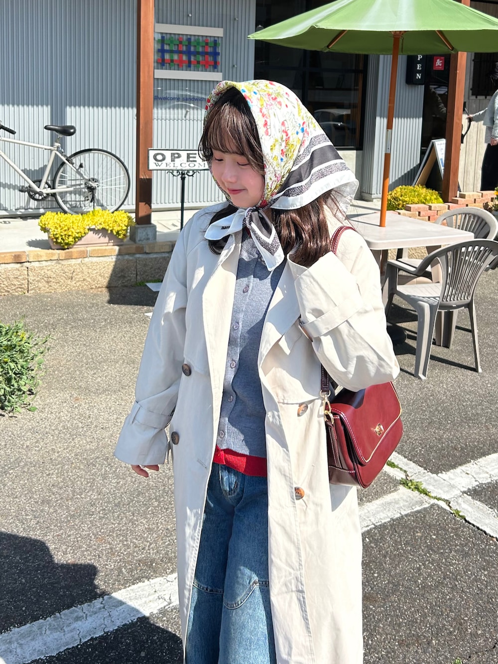 グレー系のカーディガン/ボレロ、ホワイト系のトレンチコート、レッド系のショルダーバッグを着用したレディースの春コーディネートの3枚目の写真