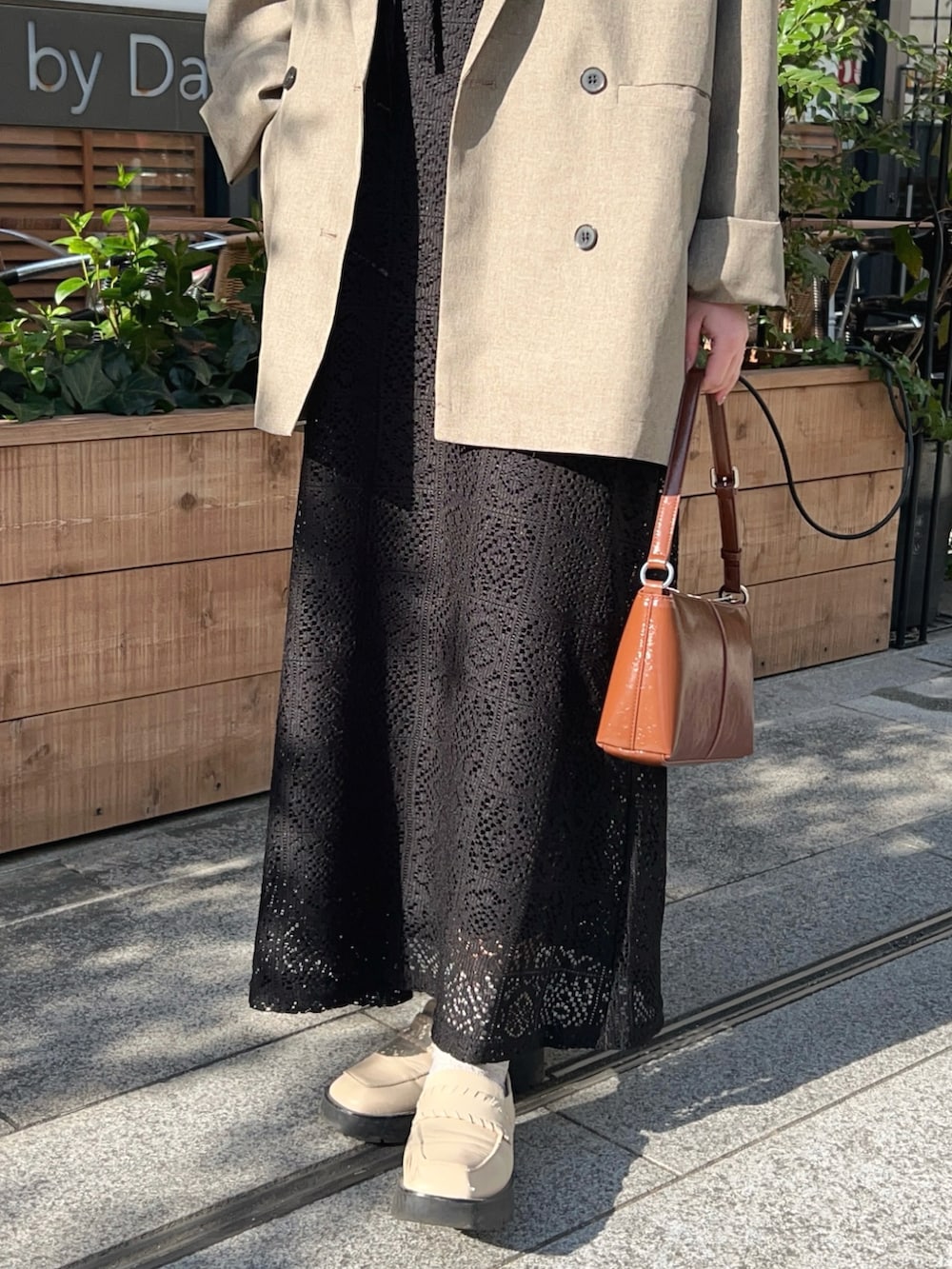 ベージュ系のテーラードジャケット、ブラック系のワンピース、その他のショルダーバッグを着用したレディースの春コーディネートの4枚目の写真