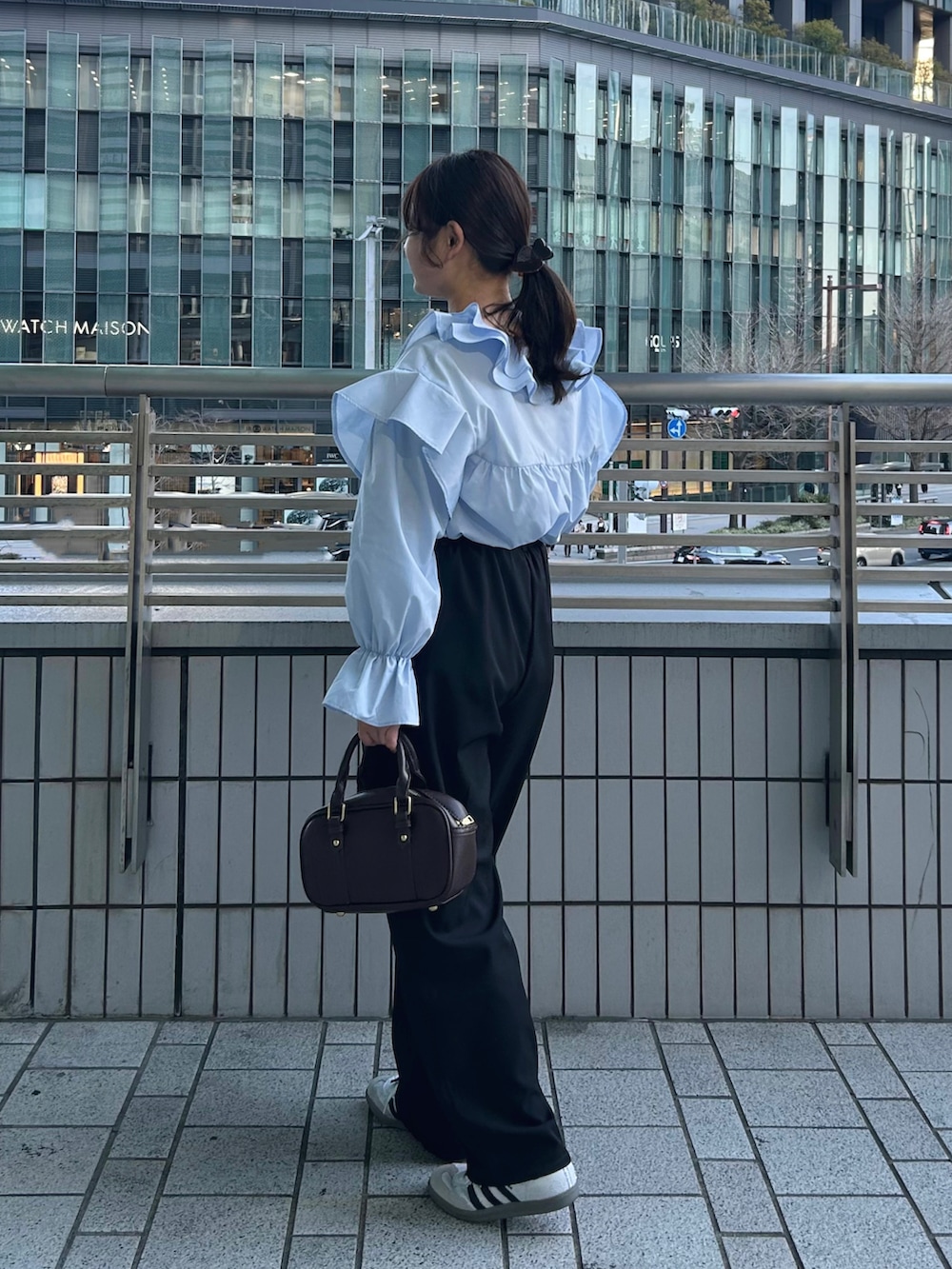 ブルー系のシャツ/ブラウス、ブラック系のその他パンツ、ブラウン系のボストンバッグを着用したレディースの春コーディネートの2枚目の写真