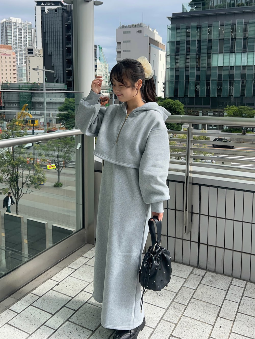 ブラック系のスニーカー、グレー系のワンピース、ブラック系のハンドバッグを着用したレディースの秋コーディネートの3枚目の写真