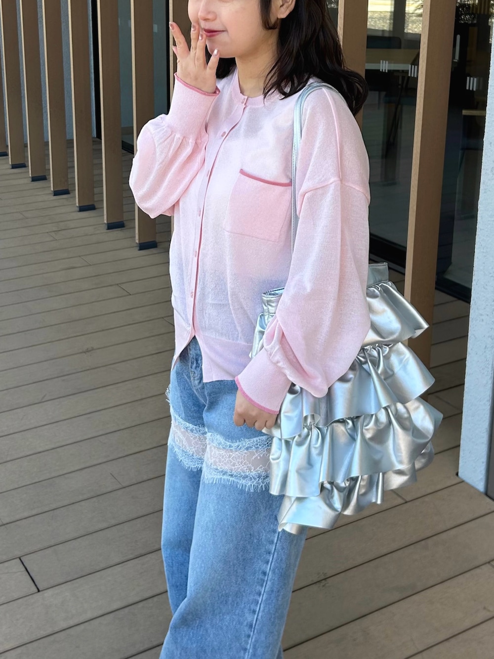 ブルー系のデニムパンツ、ピンク系のカーディガン/ボレロ、ホワイト系のタンクトップを着用したレディースの春コーディネートの4枚目の写真