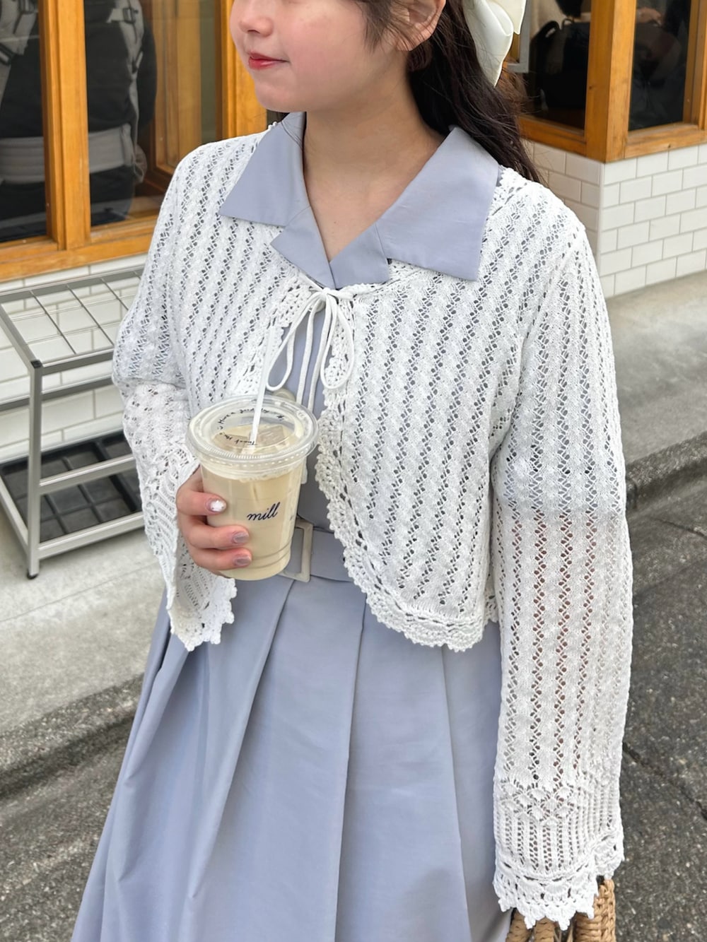 ベージュ系のかごバッグ、ホワイト系のカーディガン/ボレロ、ブルー系のシャツワンピースを着用したレディースの春コーディネートの3枚目の写真