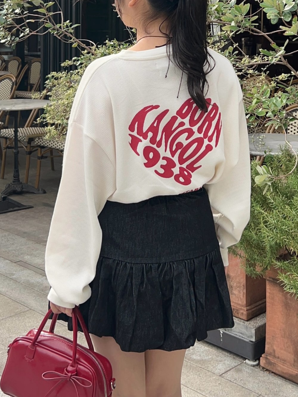 その他のTシャツ/カットソー、ブラック系のスカート、レッド系のボストンバッグを着用したレディースの秋コーディネートの2枚目の写真