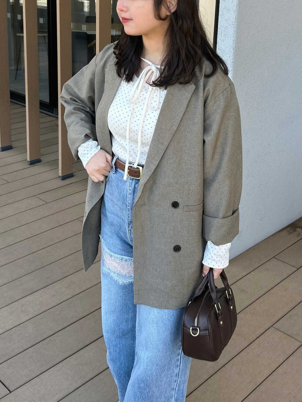 ホワイト系のTシャツ/カットソー、ベージュ系のテーラードジャケット、ブルー系のデニムパンツを着用したレディースの春コーディネートの4枚目の写真