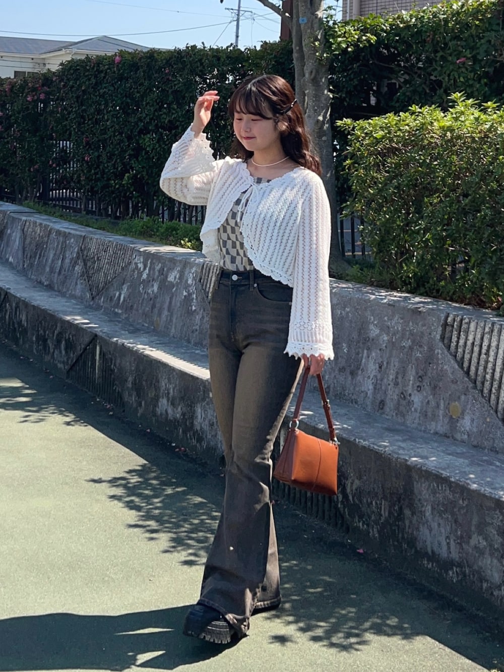 ブラック系のスニーカー、ブルー系のデニムパンツ、その他のショルダーバッグを着用したレディースの春コーディネートの3枚目の写真