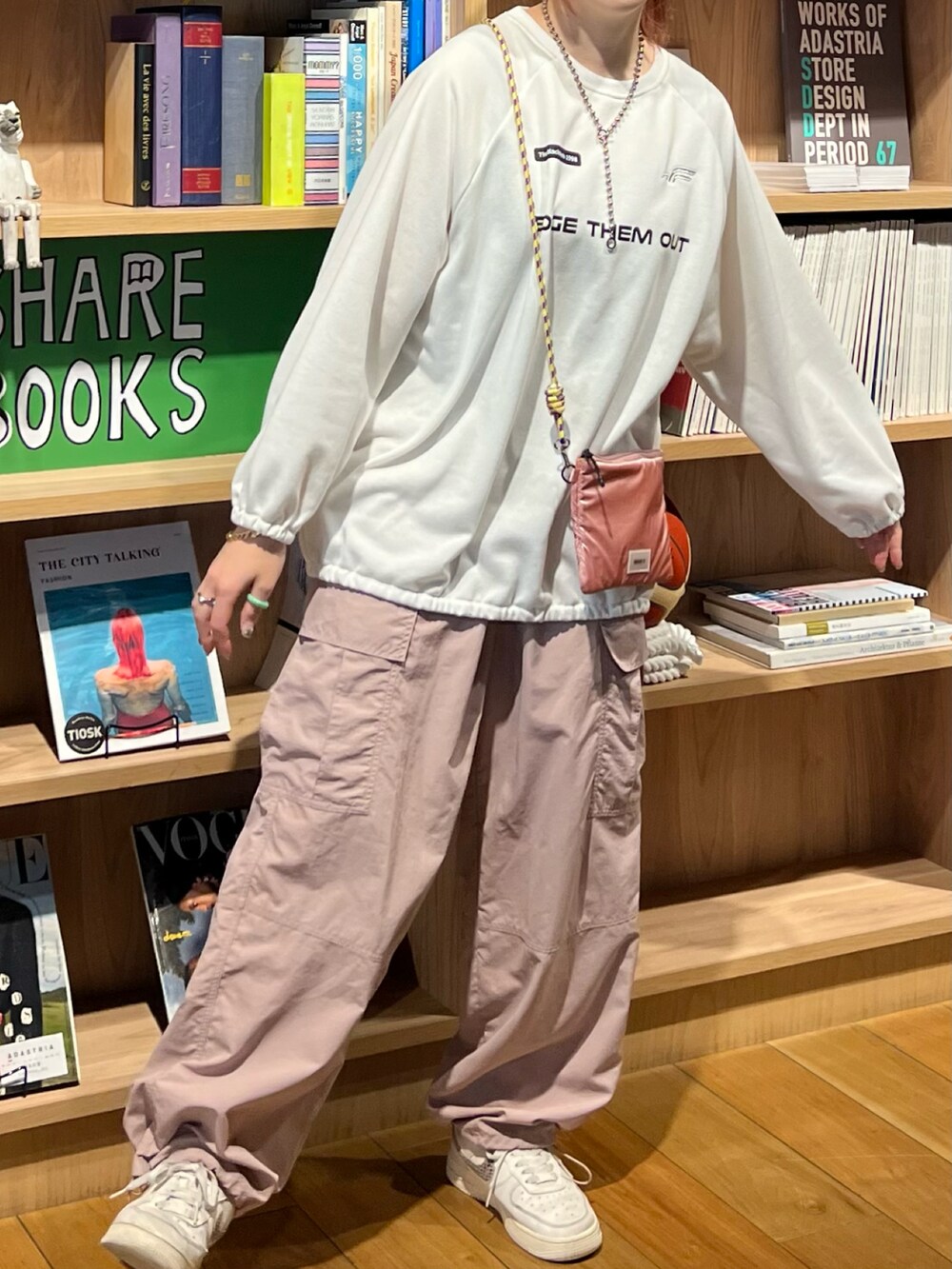 ピンク系のカーゴパンツ、ピンク系のショルダーバッグ、ホワイト系のスウェットを着用したレディースの春コーディネートの3枚目の写真