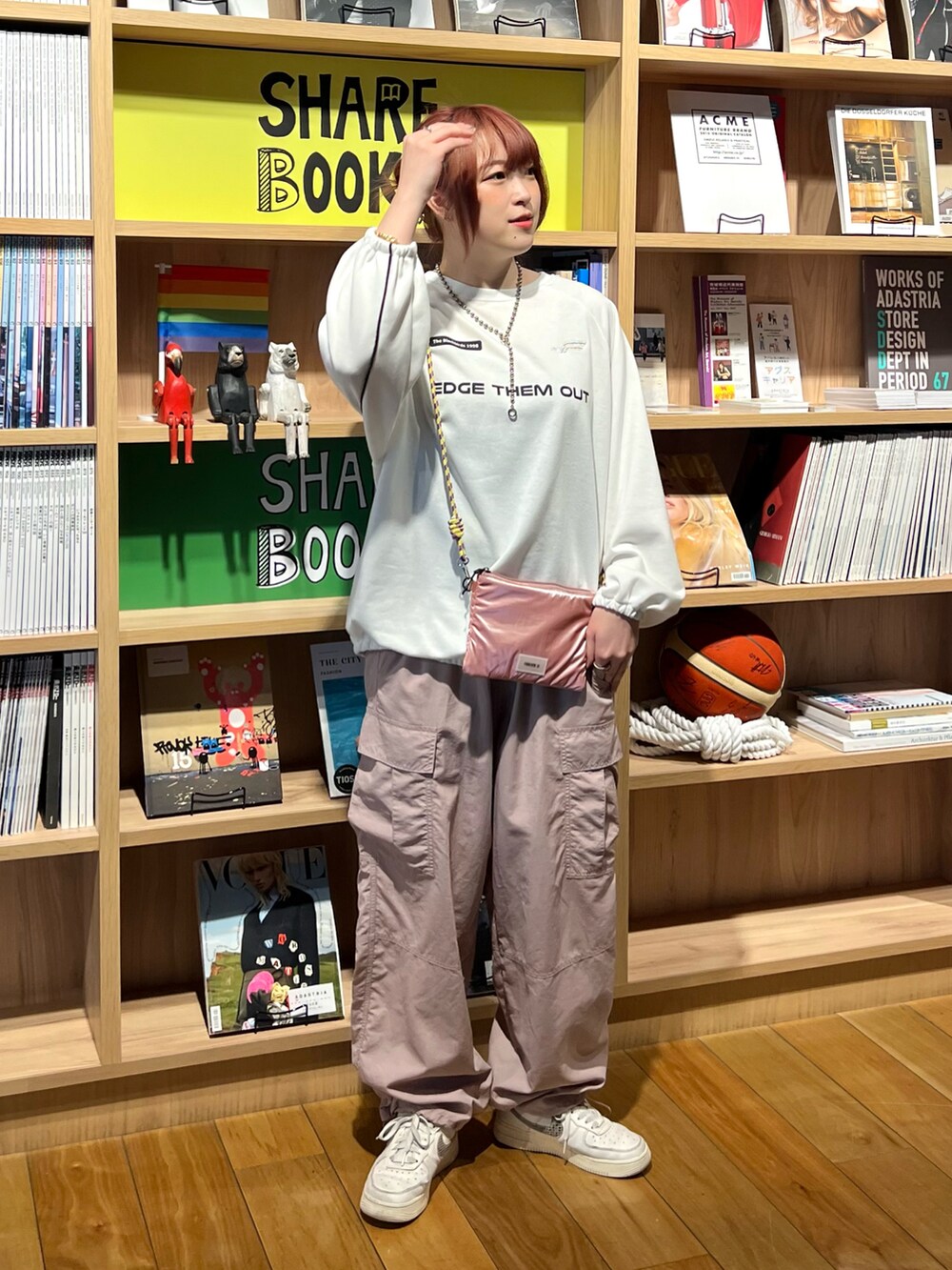 ピンク系のカーゴパンツ、ピンク系のショルダーバッグ、ホワイト系のスウェットを着用したレディースの春コーディネートの4枚目の写真