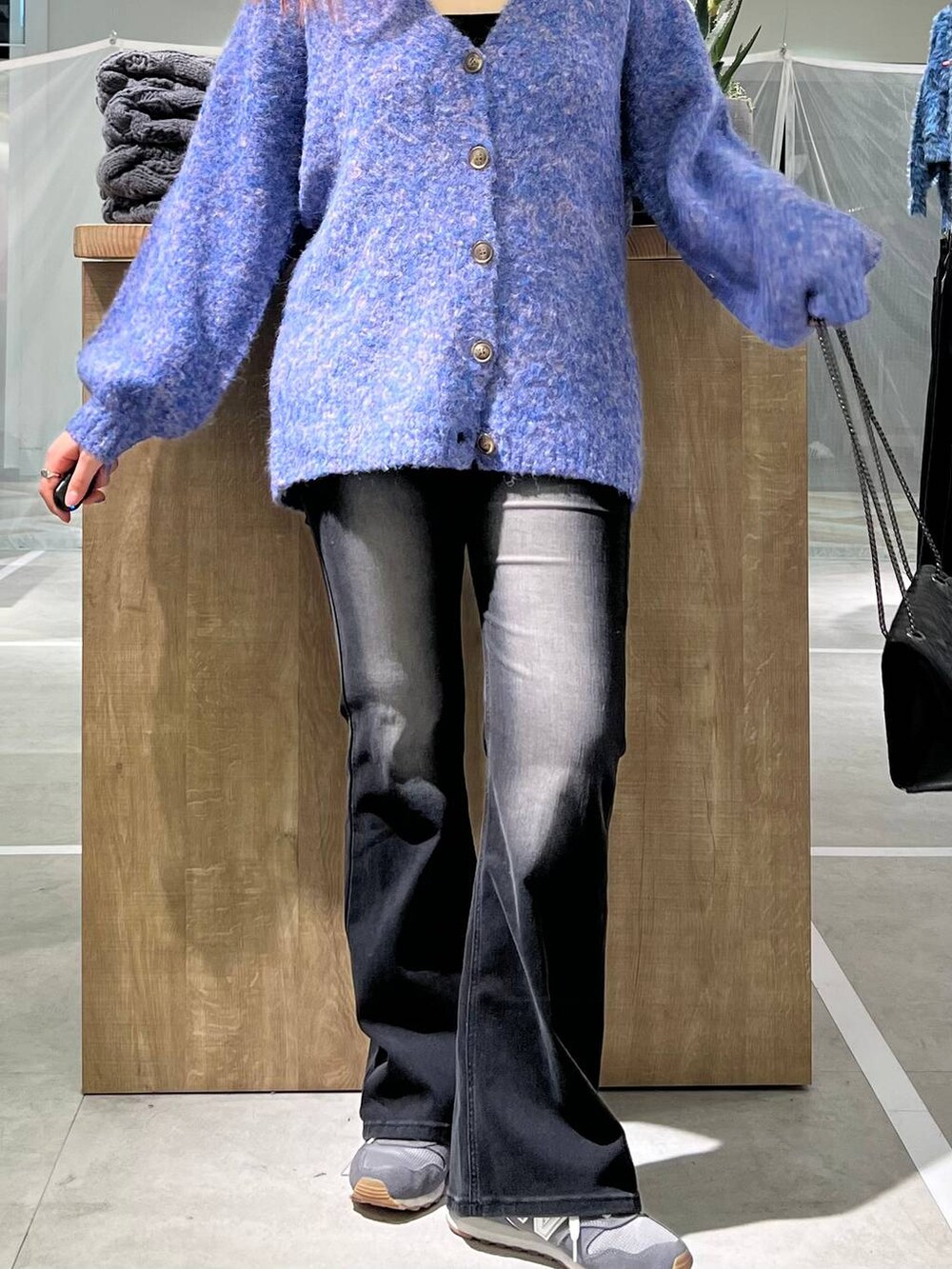 ブルー系のカーディガン/ボレロ、ブラック系のデニムパンツを着用したレディースの冬コーディネートの2枚目の写真