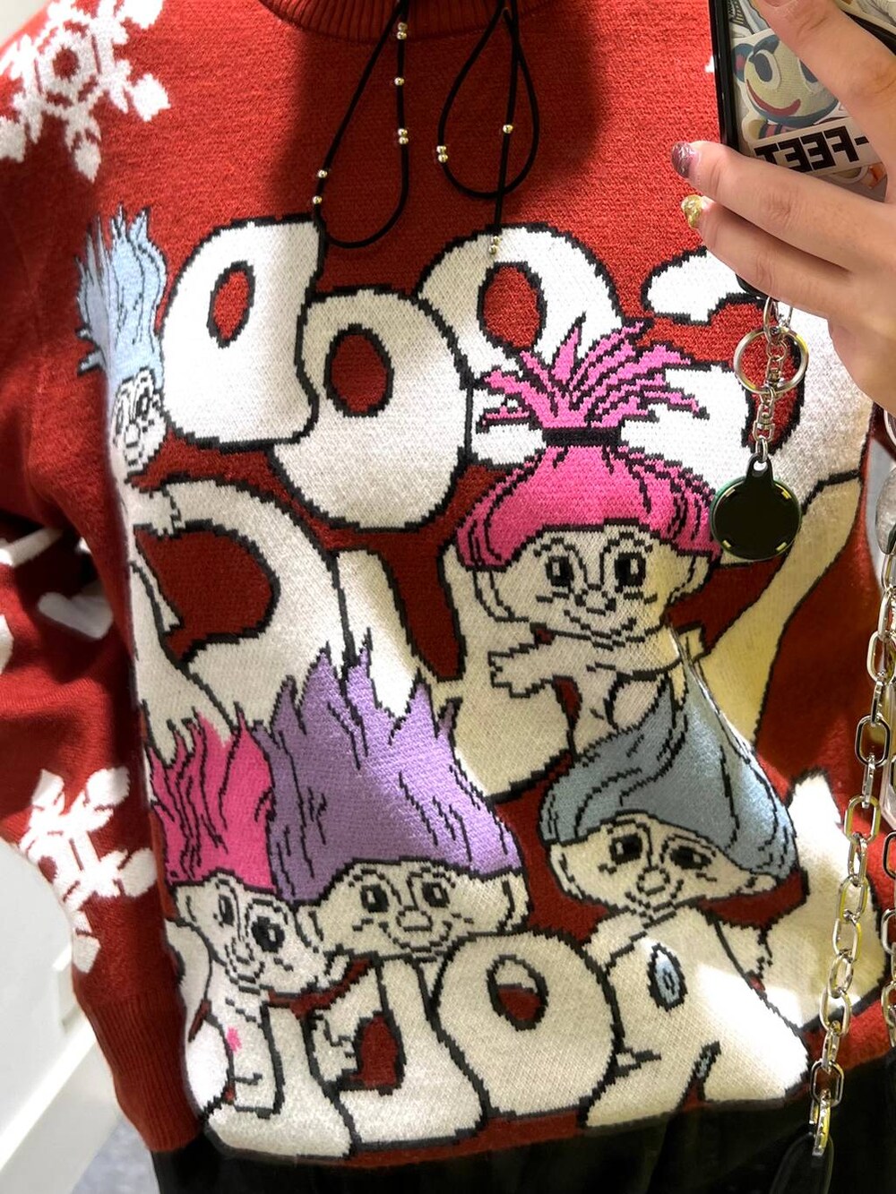 ブラック系のカーゴパンツ、レッド系のニット/セーター、ブラック系のスマホグッズを着用したレディースの秋コーディネートの5枚目の写真