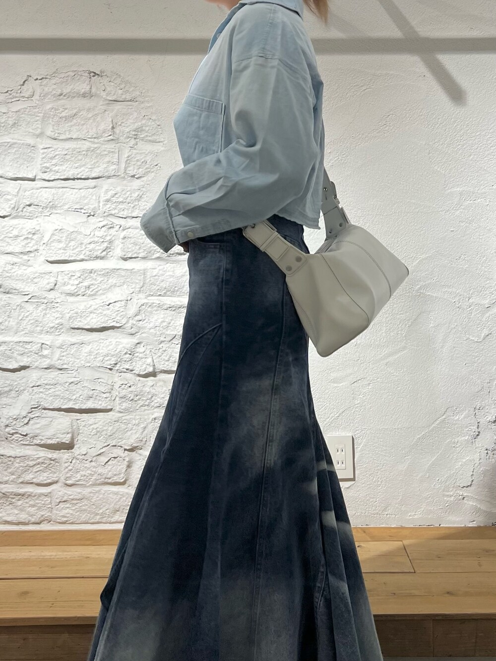 ブルー系のデニムスカート、ブルー系のシャツ/ブラウス、ホワイト系のショルダーバッグを着用したレディースの夏コーディネートの4枚目の写真