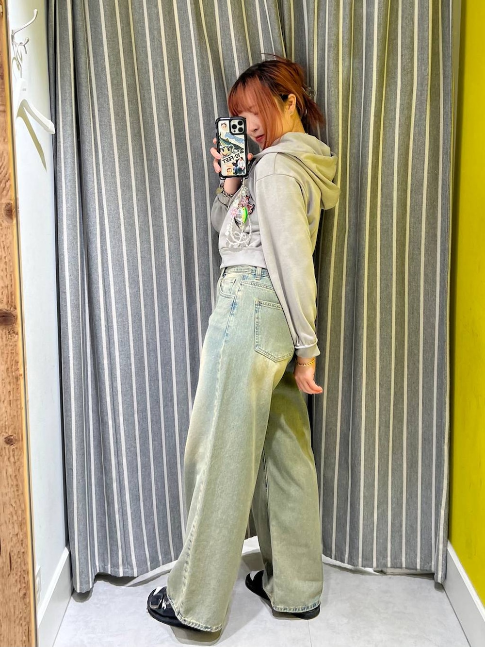 ブルー系のデニムパンツ、グレー系のパーカーを着用したレディースの秋コーディネートの2枚目の写真